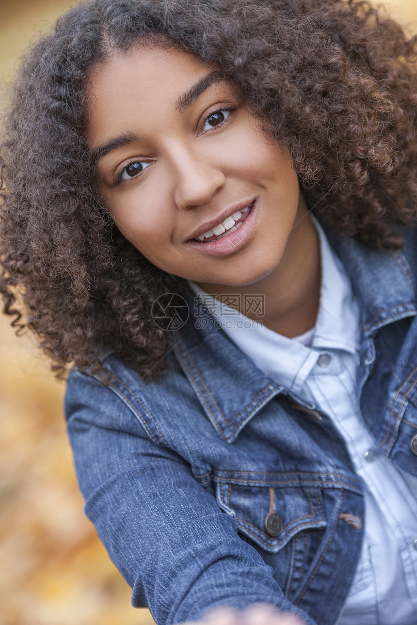 户外肖像美丽的快乐混合种族非裔美国女孩十几岁的女孩子微笑与完美的牙齿图片