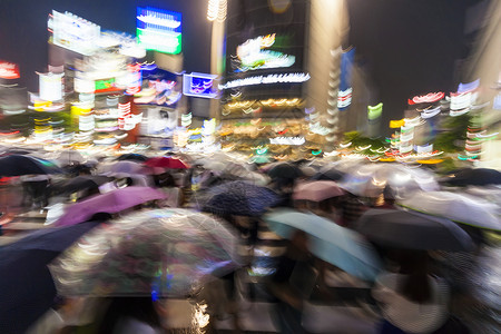 运动模糊了人们雨中夜间的涩谷渡口,东京,日本图片