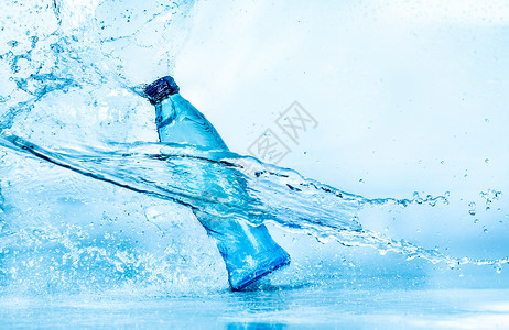 瓶水溅蓝色的背景上图片
