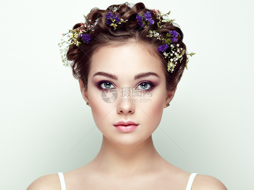 用花装饰的美丽女人的脸完美的妆容美容时尚睫毛化妆品眼影图片