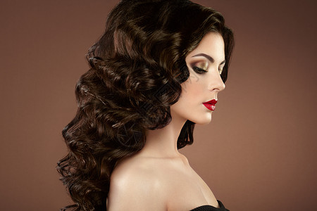 头发卷曲的黑发女人美丽的女孩长着波浪状的长发完美的妆容时尚照片图片
