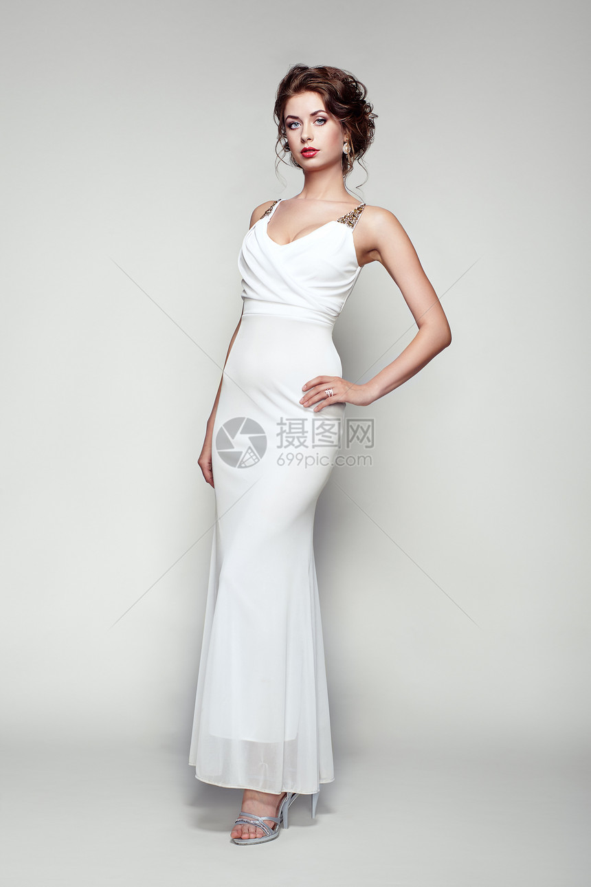 穿着优雅白色连衣裙的美丽女人的时尚肖像着优雅发型珠宝的女孩图片
