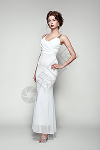 穿着优雅白色连衣裙的美丽女人的时尚肖像着优雅发型珠宝的女孩图片