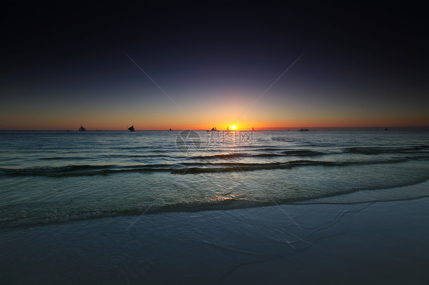 日落时的游艇日落时热带海洋航行的游艇图片