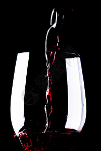 黑色背景的酒杯中的红酒图片