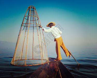 复古效果过滤了缅甸旅游景点的时髦风格形象传统的缅甸渔民inle湖渔网,以其独特的单腿划船风格而闻名缅甸inle湖的传背景图片