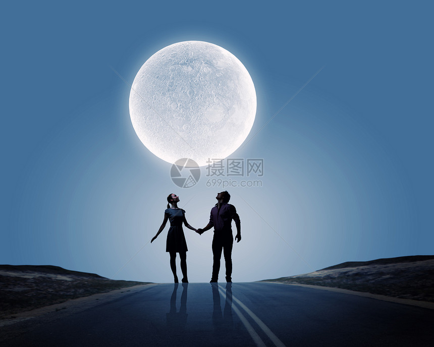 浪漫的站月光下的轻浪漫夫妇的剪影