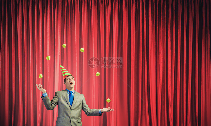 商人玩弄球轻的商人戴着帽子舞台上玩球图片