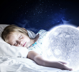 晚安女孩躺床上,手里着月亮困乏的高清图片素材