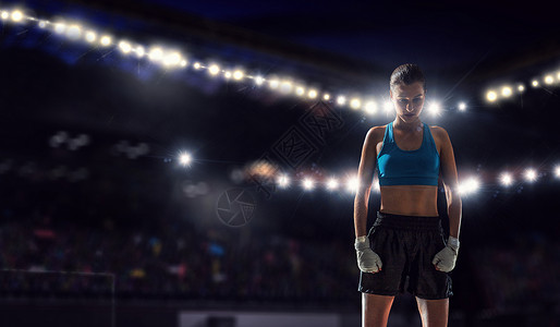 戒指上的轻拳击手女人轻漂亮的拳击手女人站运动场的灯光下竞技场高清图片素材