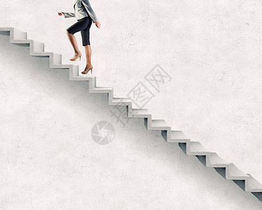 上职业阶梯轻的女商人走楼梯上,代表着成功的背景图片