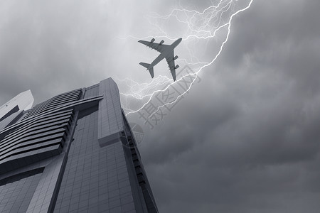 城市上空的飞机暴风雨的天空中,飞机摩天大楼上方飞行的底部视图图片