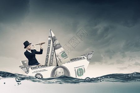 美元纸船女商人漂浮水上的美元钞票上图片