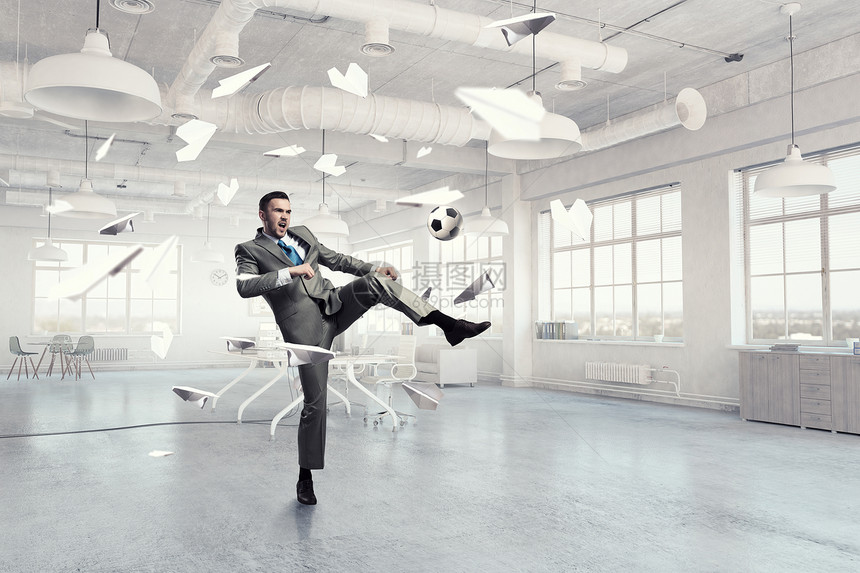 办公室踢足球穿着西装的商人现代办公室跳着打足球图片