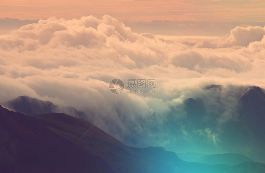 美丽的日落云层上方的山上图片