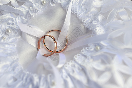 新娘枕头上两个金色的结婚戒指图片