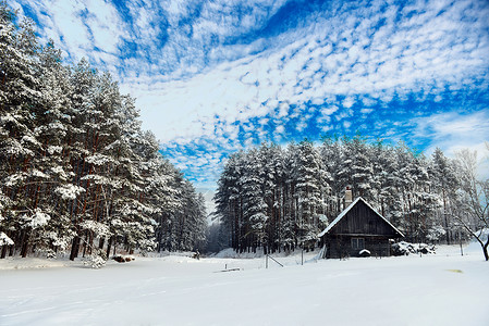 冰湖岸边的小屋,然后冬天的森林背景图片
