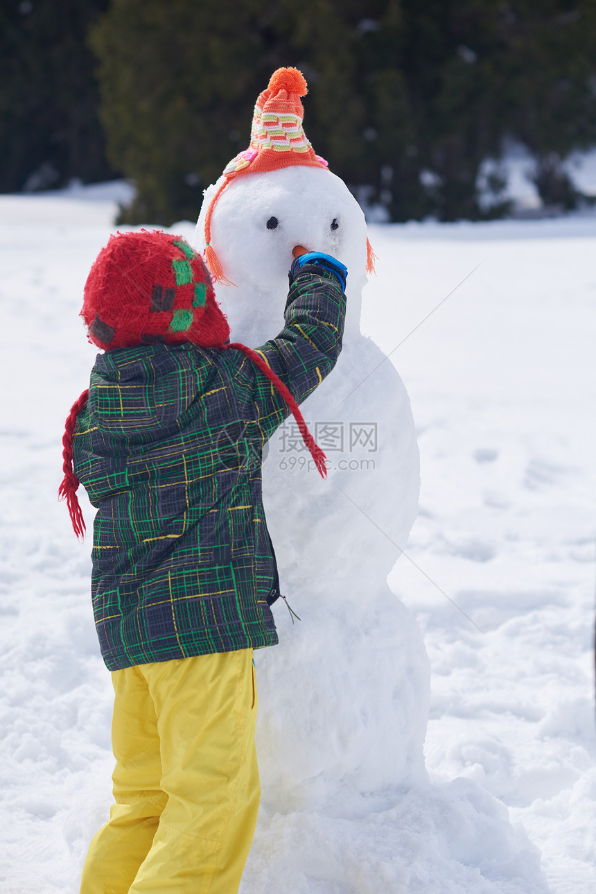 小男孩堆雪人图片