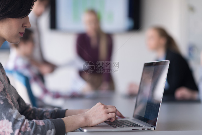 轻的商务女现代初创公司办公室内部工作笔记本电脑上,会议上嘘队,背景中分图片