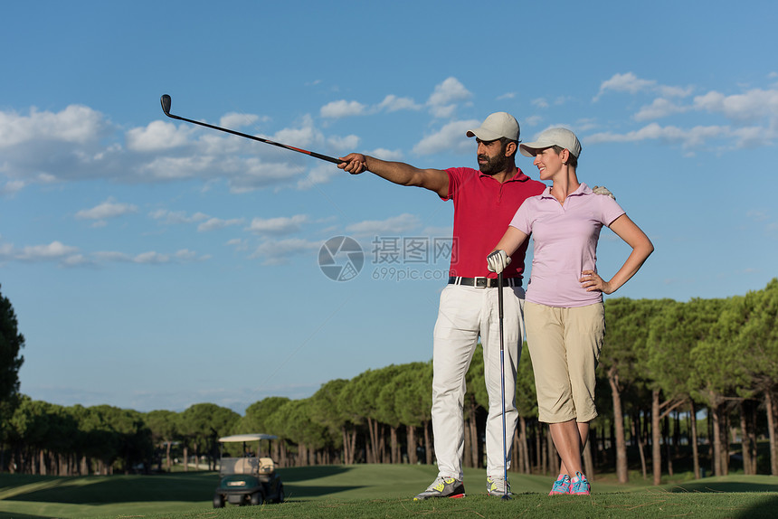 高尔夫球场上幸福轻夫妇的肖像图片