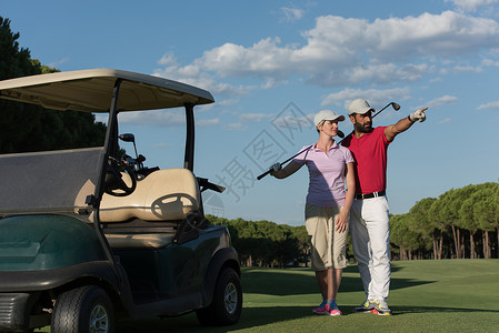 高尔夫球场上快乐的轻高尔夫球手夫妇的肖像图片