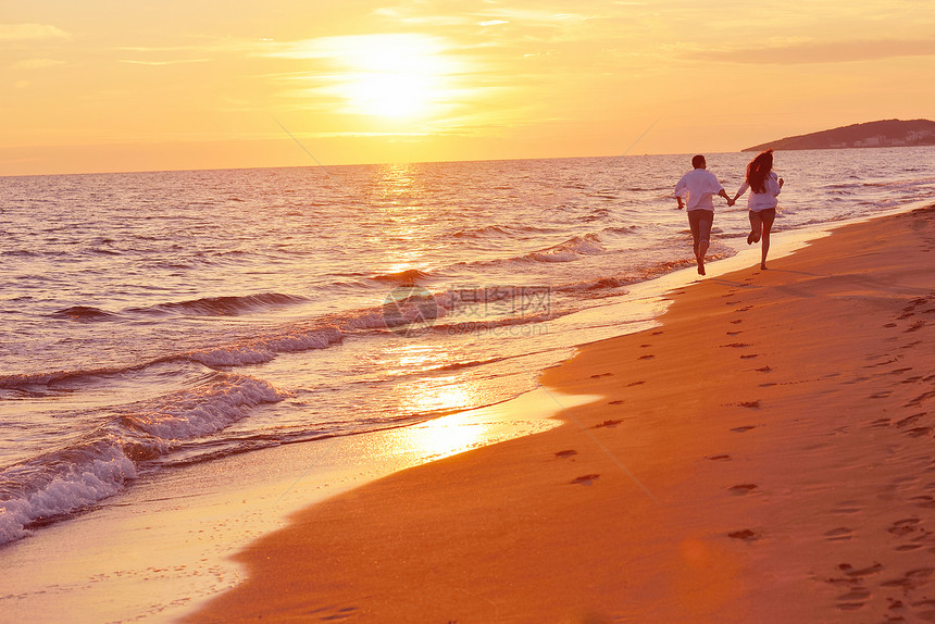 快乐的轻浪漫情侣美丽的夏日美丽的海滩上玩得开心图片
