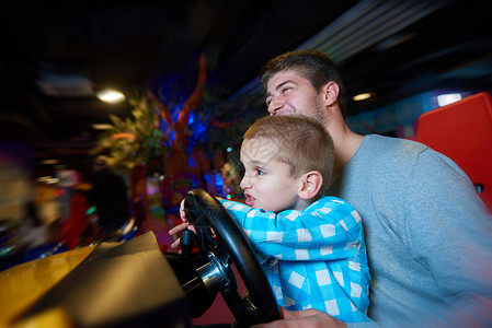 快乐的父子操场公园玩驾驶轮电子游戏图片