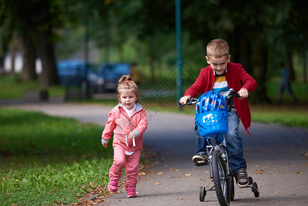 快乐的孩子公园,男孩女孩大自然与自行车玩得开心图片