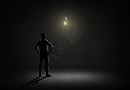 商业,人,灵感想法商人后看黑暗房间里的灯泡背景图片