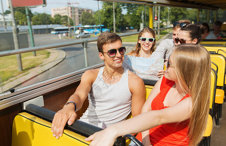 旅游,暑假,观光人的群微笑的青少朋友戴着太阳镜,乘旅游巴士旅行图片