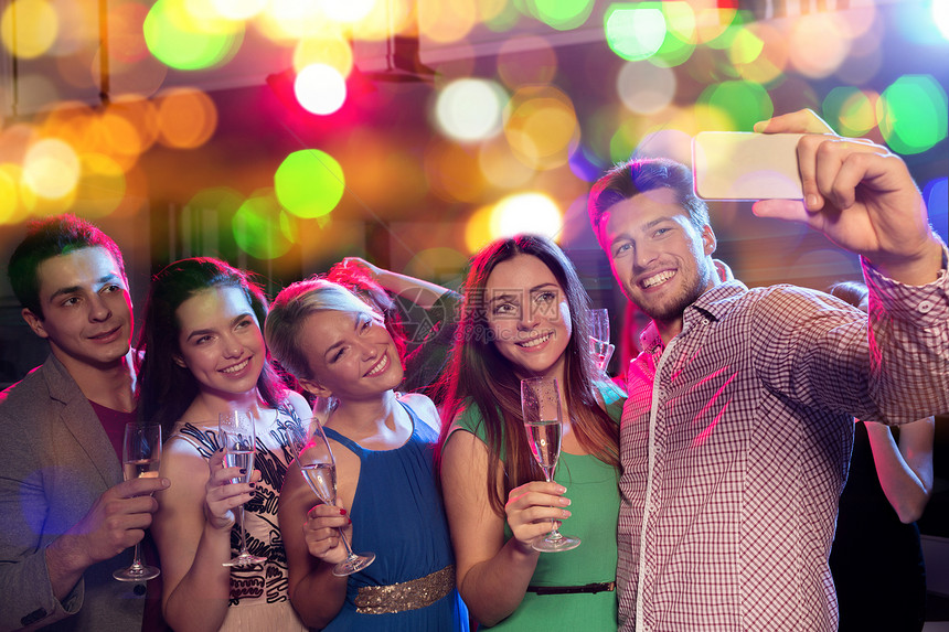 派,假日,技术,夜生活人们的微笑的朋友带着杯含酒精的香槟智能手机俱乐部自拍图片