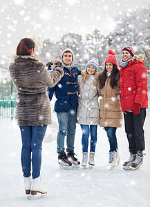 人,友谊,技术休闲快乐的朋友户外滑冰场用智能手机拍照图片