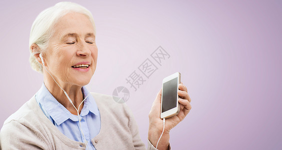 技术,龄人的快乐的老年女子与智能手机耳机听音乐紫罗兰背景图片