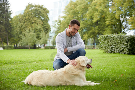 家庭,宠物,动物人的快乐的人与拉布拉多猎犬城市公园散步图片