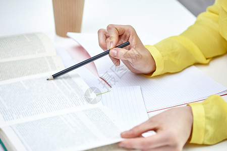 人与教育的学校,女的手把铅笔指向书本教科书用书笔记本合上女的手图片