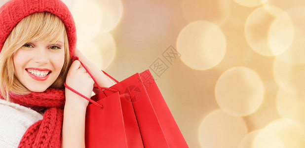 幸福,寒假,诞节人们的微笑的轻女人戴着帽子围巾,米灯光下的购物袋背景图片