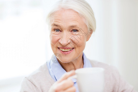 龄,饮料人的快乐的微笑老妇女家里喝杯茶咖啡杯子高清图片素材