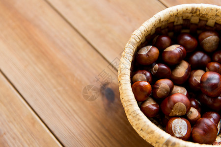 自然,季节,秋天植物学的栗子柳条篮子木制桌子上背景图片