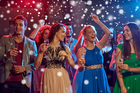 新派,假期,庆祝,夜生活人们的微笑的朋友俱乐部雪的效果中碰杯含酒精的香槟啤酒背景图片