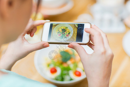 人,休闲技术的近距离的女人手与智能手机拍照的食物餐厅背景图片