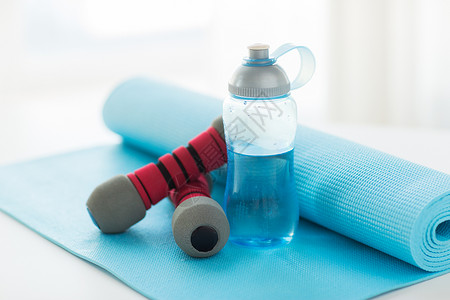 运动,健身,健康的生活方式物品的瓶与水,哑铃运动垫图片