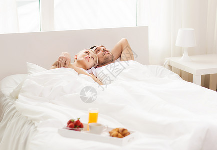 人,爱,关怀幸福的幸福的夫妇躺床上,家里盘早餐图片