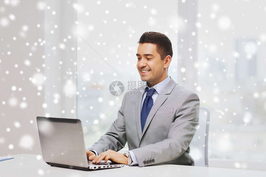 商业,人技术快乐的微笑商人穿着西装,办公室里用笔记本电脑工作,雪的效果图片