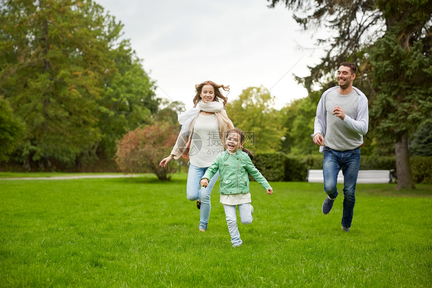 家庭亲子休闲人的快乐的母亲父亲小女孩夏天的公园里跑步玩接球游戏图片
