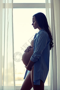 怀孕,母亲,人期望幸福孕妇的剪影,大裸肚子家里的窗户附近图片