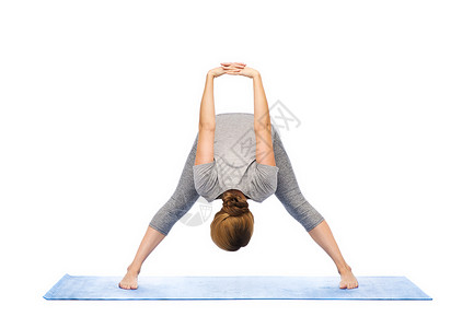 健身,运动,人健康的生活方式妇女瑜伽宽腿向前弯曲姿势垫子上背景