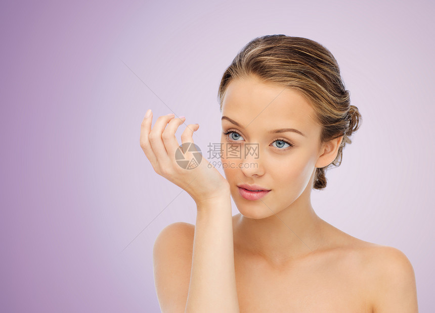 美丽,香气,人身体护理的轻的女人闻香水她的手腕上的紫色背景图片