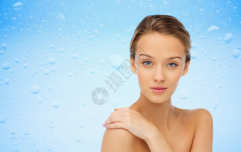 美丽,人,身体护理健康理念微笑的轻女人的脸手裸露的肩膀上,水滴蓝色的背景上图片