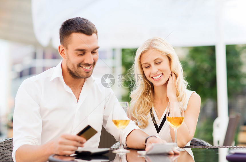 日期,人,付款关系的幸福的夫妇与信用卡,账单酒杯餐厅露台图片