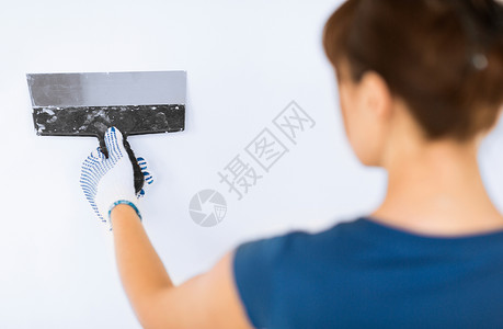 室内家庭装修妇女用铲子抹灰墙壁女人用铲子把墙抹灰图片
